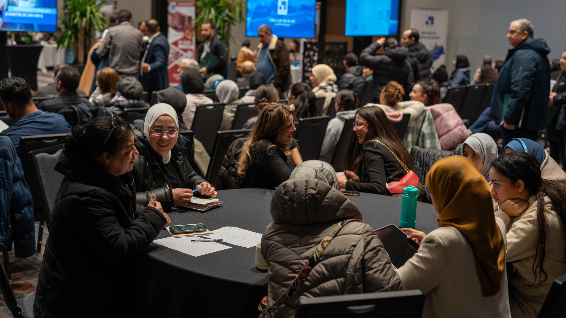 Visitors gathered around tables at the 2025 real estate salon